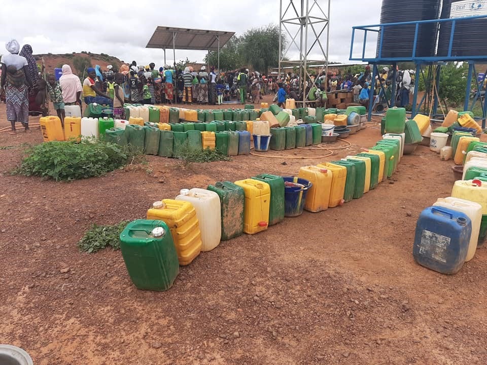 Blocs de latrines et file d’attente à la borne fontaine sur un des sites de déplacés internes à Kaya en août 2020. Crédit photo : Bassératou Kindo